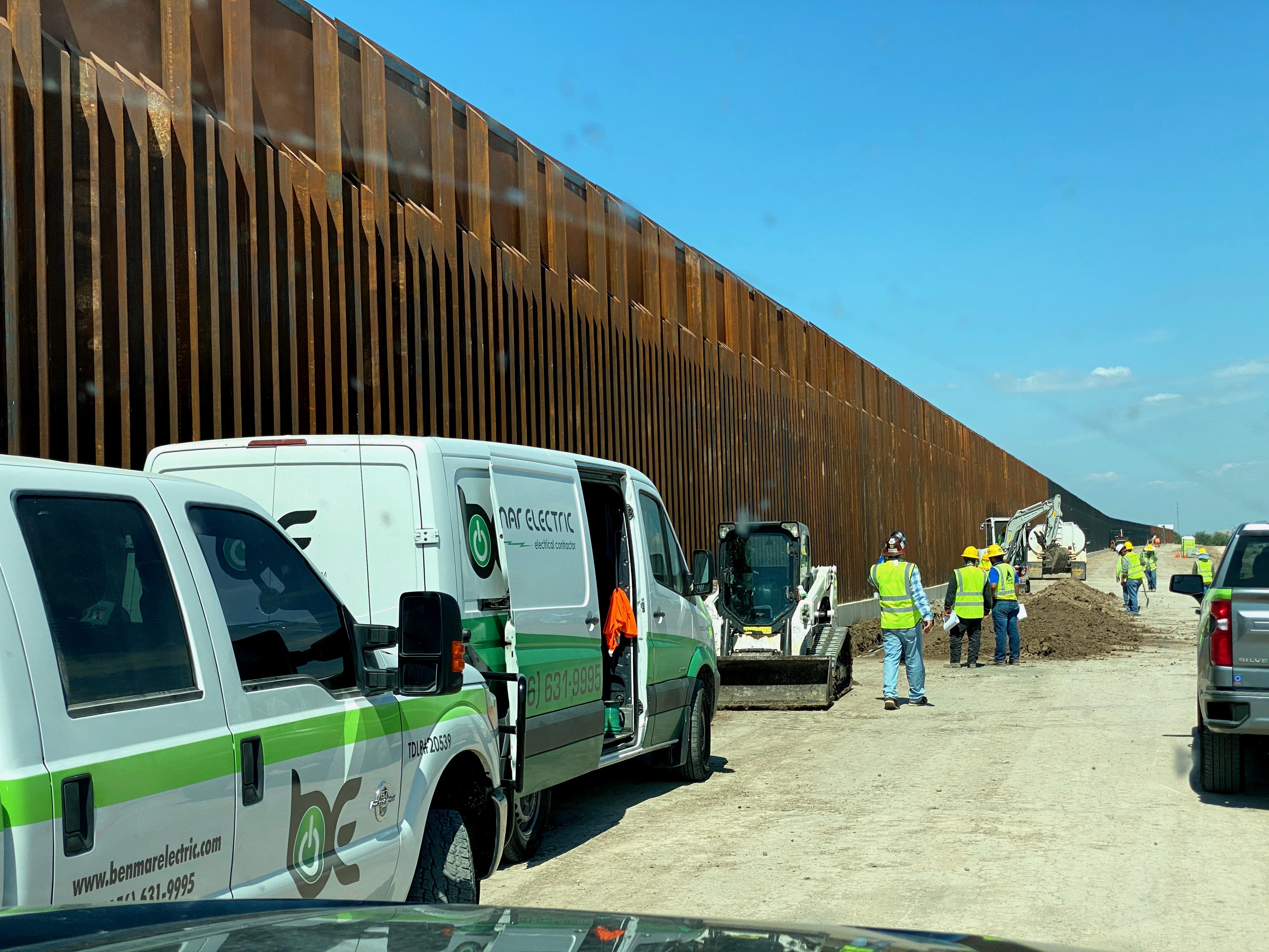 Benmar Electric vans and crew at border wall job site