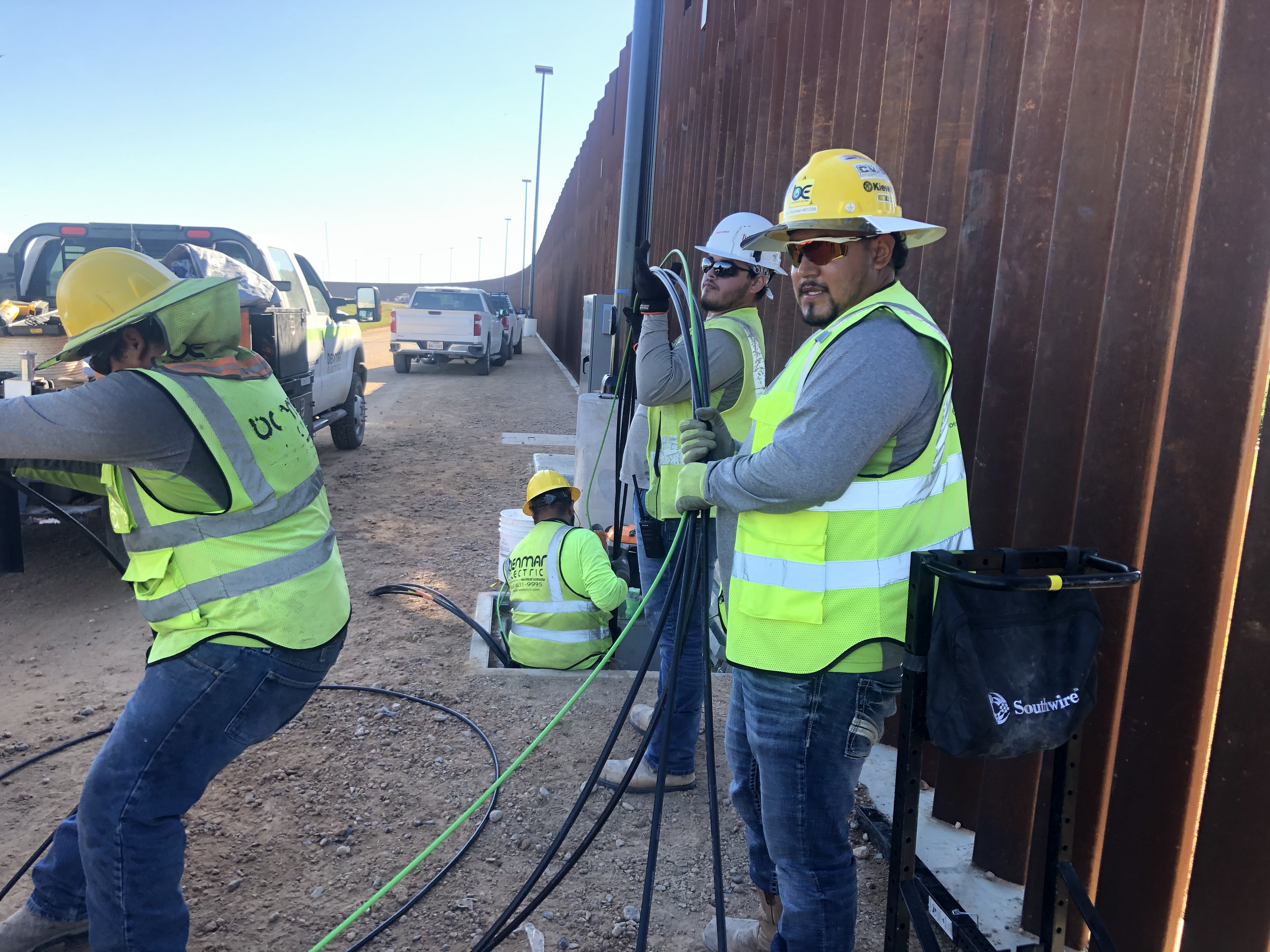 Benmar crew pulling cable at border wall